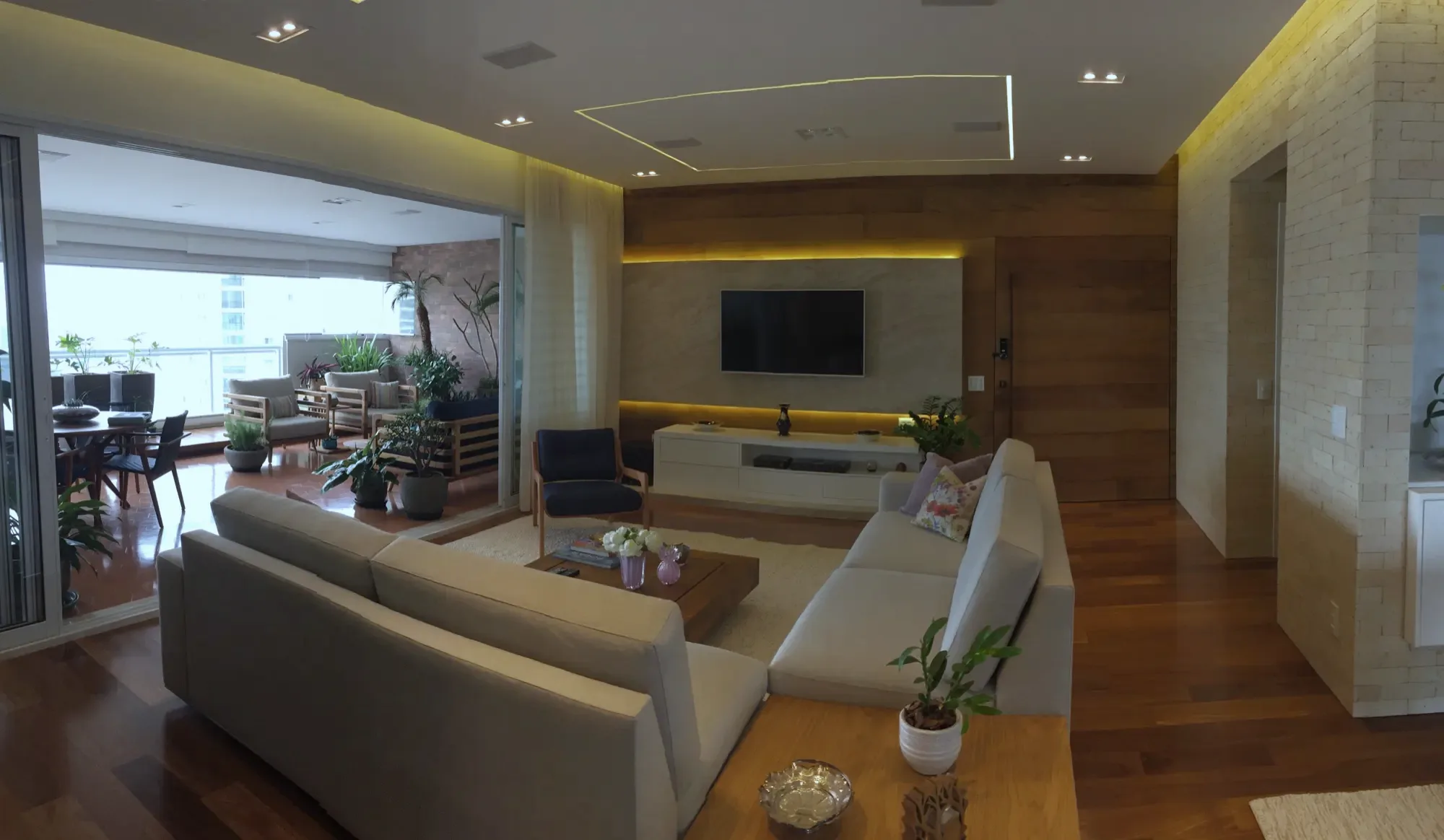 Living integrado com marcenaria clara e iluminação embutida, obra entregue pela Abbitá