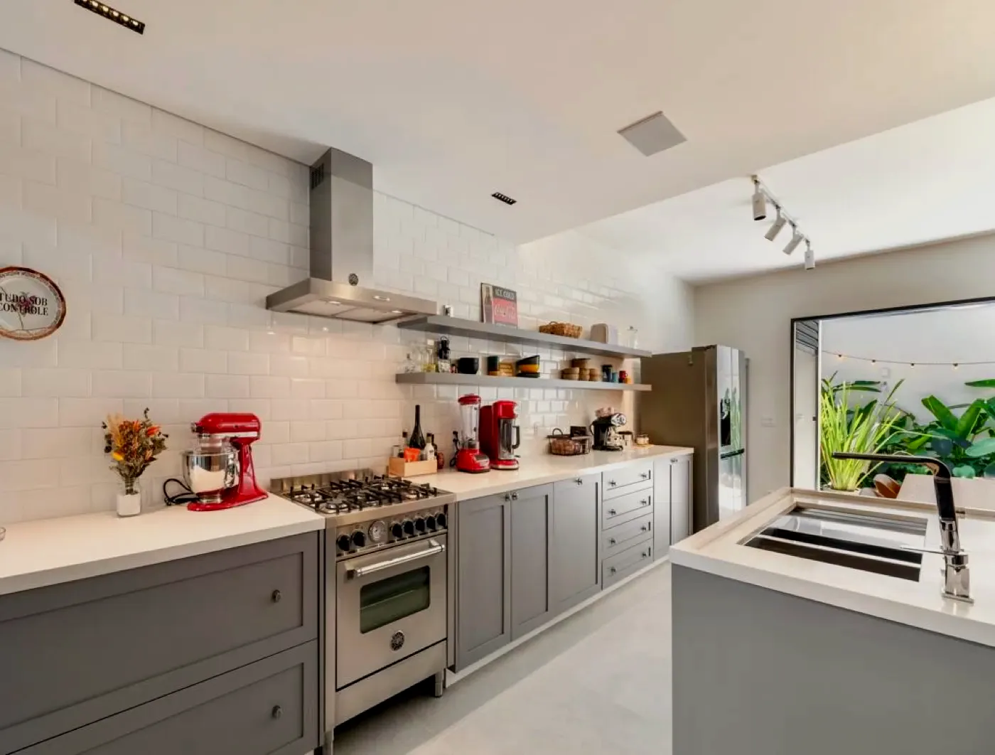 Cozinha branca com coifa, cooktop e marcenaria cinza